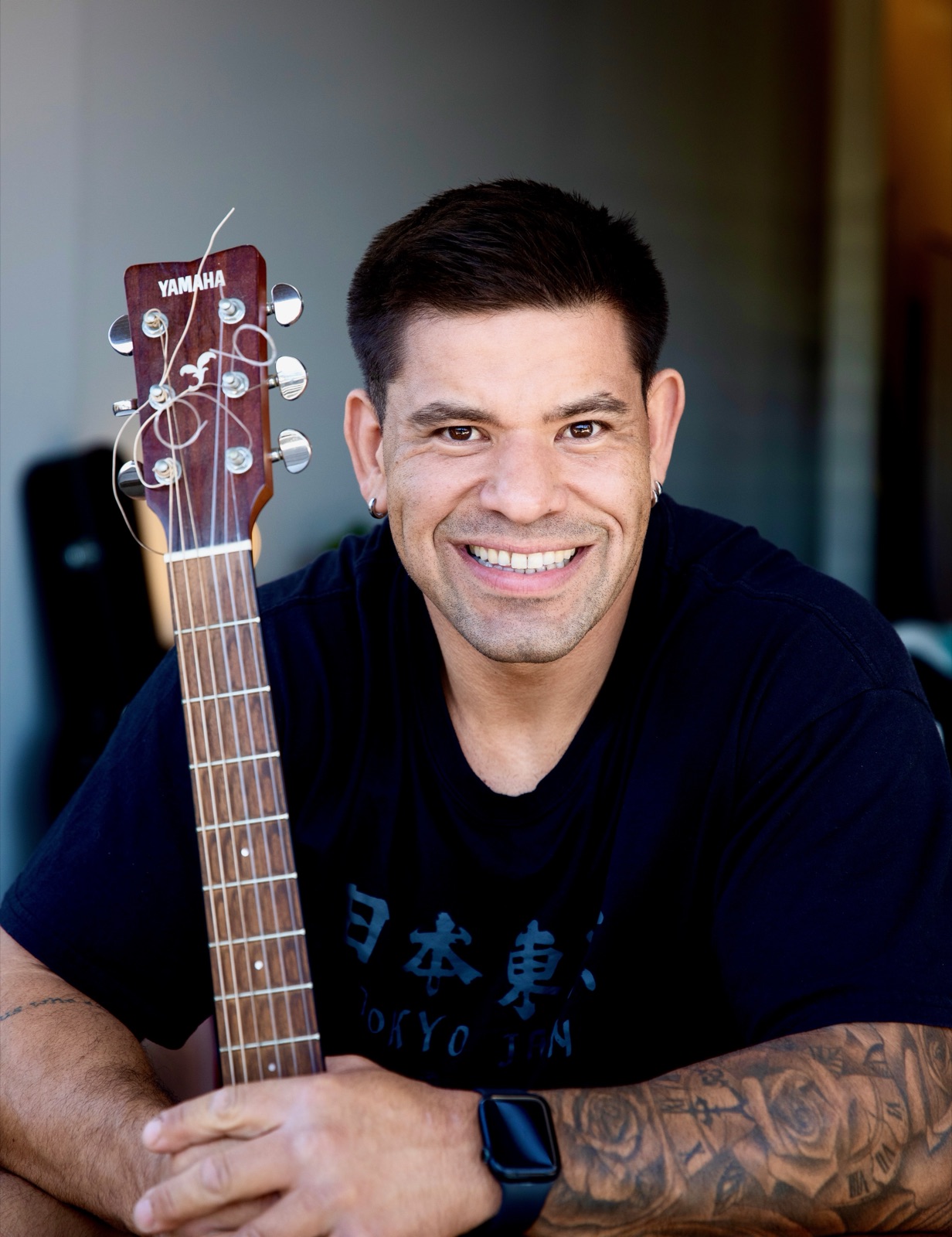 Portrait of Renan Bueno with a guitar